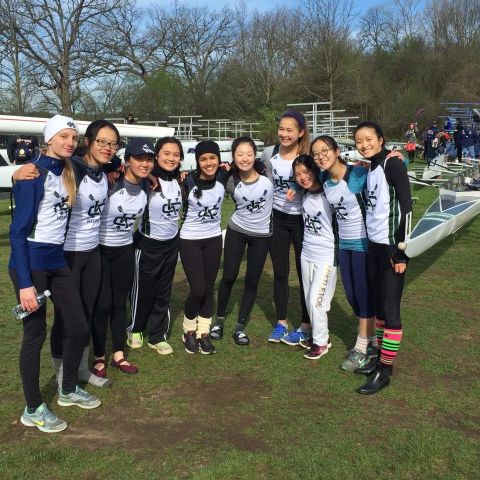 High school students in rowing uniforms smiling happily.