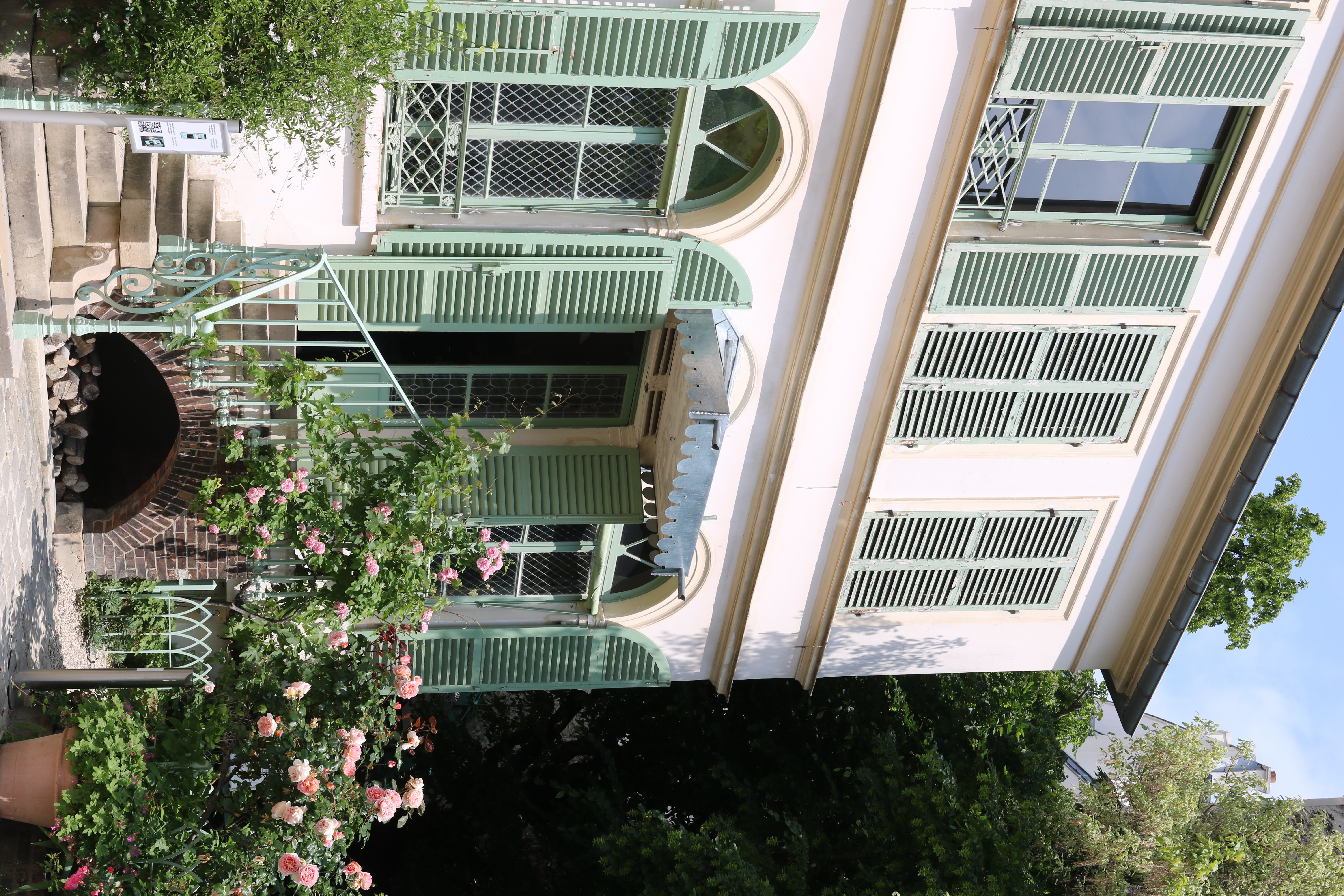 Pink facade with green window panels.